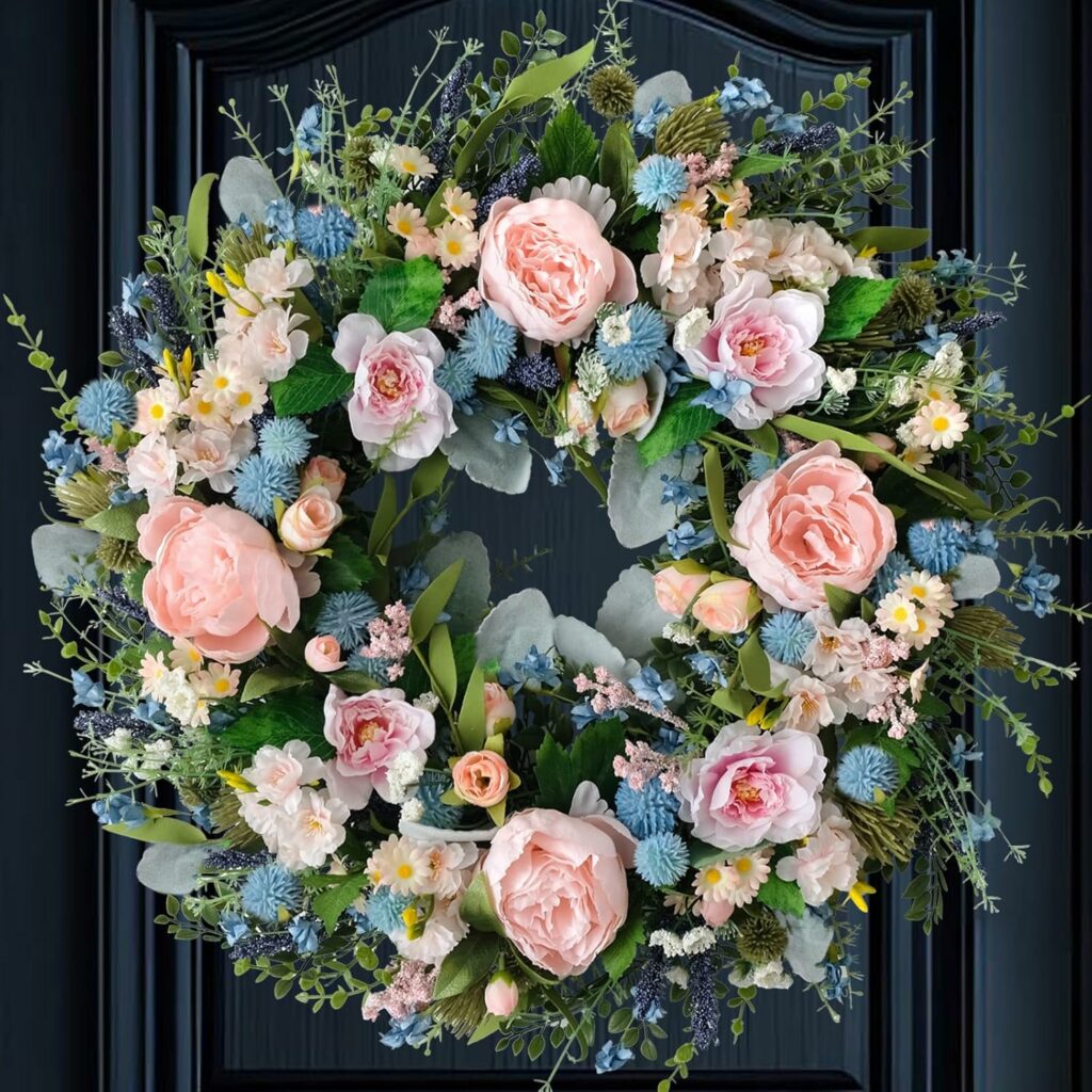 Soft pink peony wreath with full floral design and greenery hanging on front door for spring decor